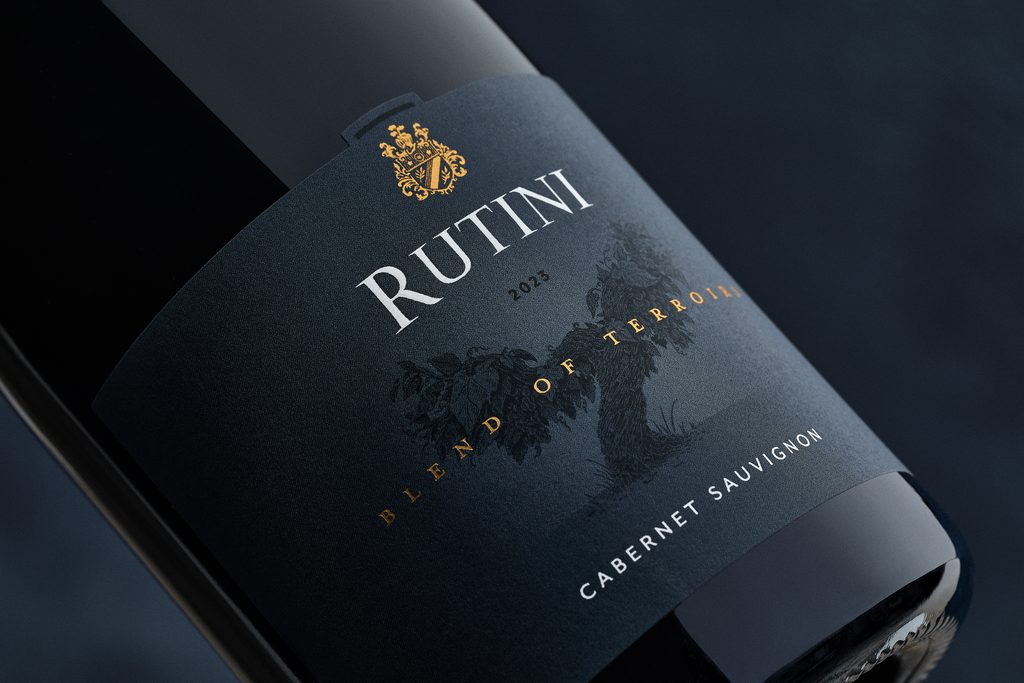 Rótulo do vinho tinto Rutini Blend of Terroirs Cabernet Sauvignon em uma garrafa deitada sobre fundo escuro.